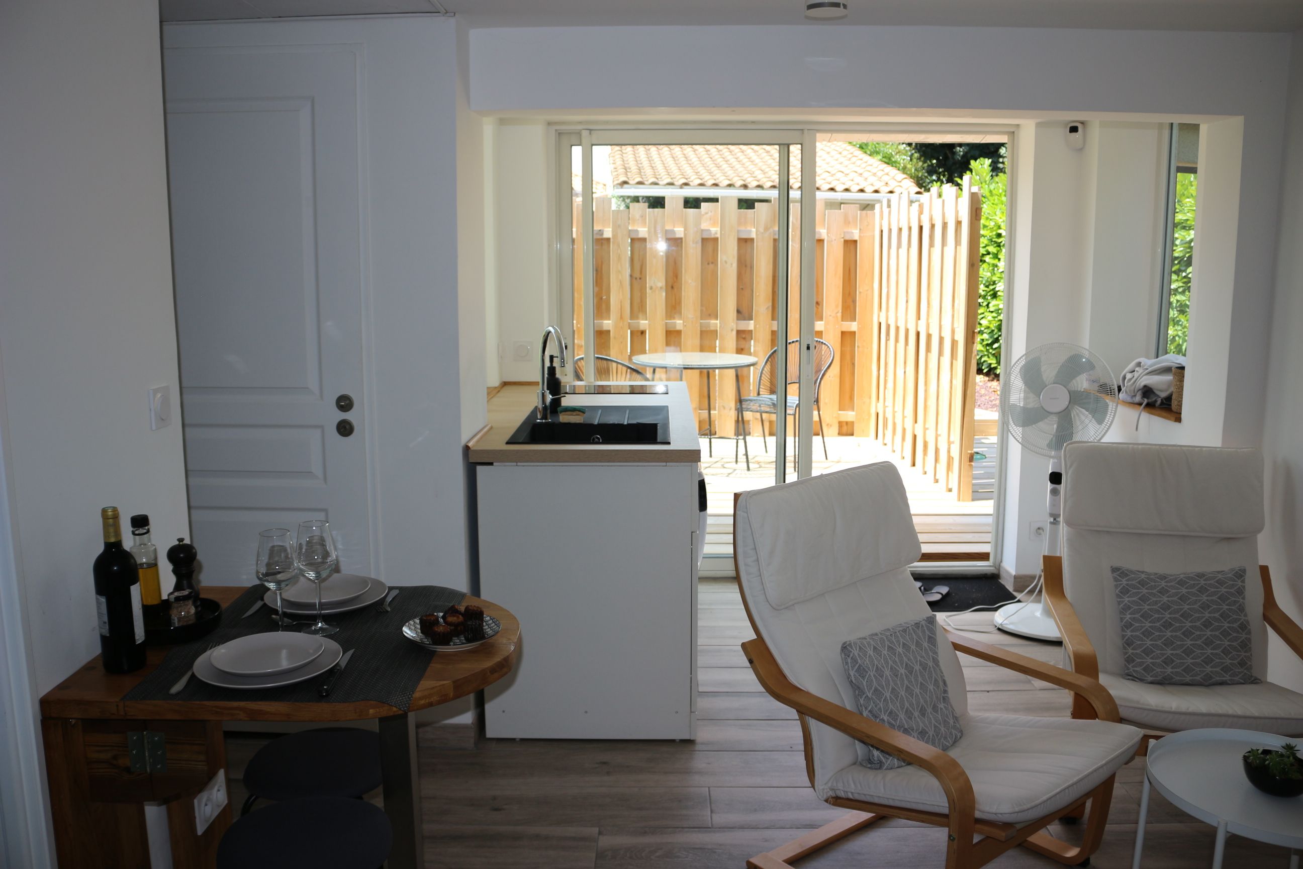 Cocina compacta con zona de comedor, una mesita y una silla.