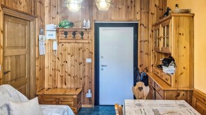 A wooden interior with a bed, a desk, a chair, a cabinet, and a door. - GRAN PARADIS (San Pietro)