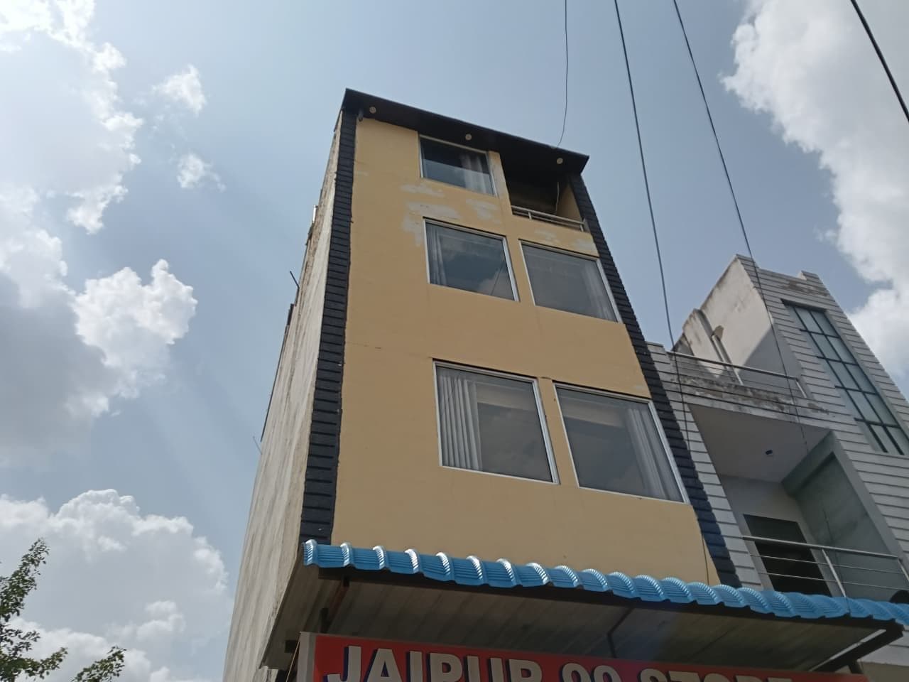 Un edificio de varios pisos con techo plano y una señal visible en la parte inferior.