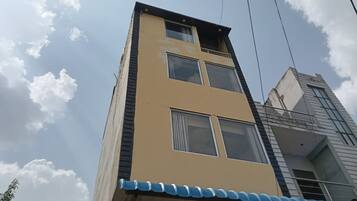 Un edificio de varios pisos con techo plano y una señal visible en la parte inferior.