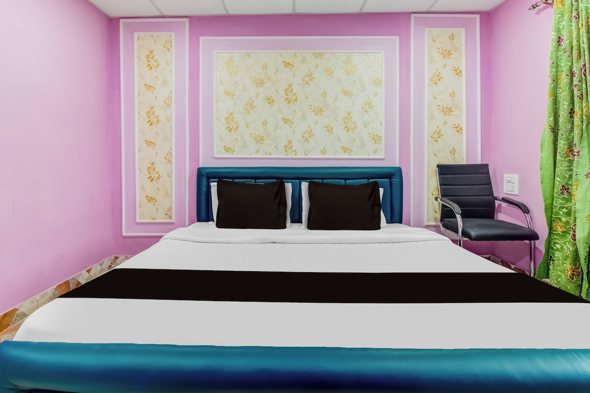 A bedroom with a bed, a chair, and a window with curtains.