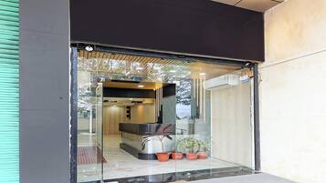 A modern reception area with a reception desk, potted plants, and a view of the interior.
