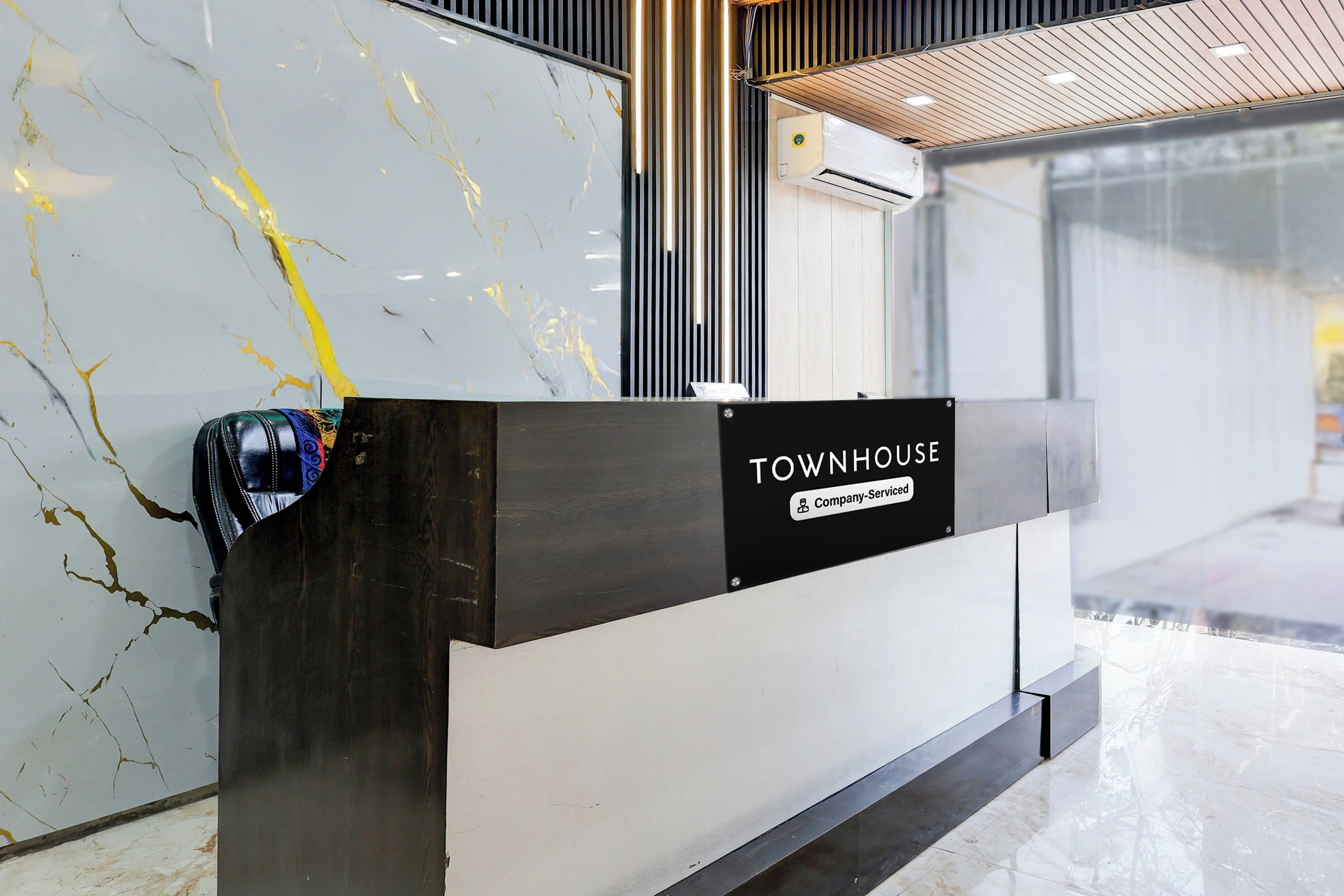 A reception desk with a sign reading 'TOWNHOUSE' and 'Company-Serviced.'