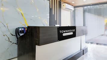 A reception desk with a sign reading 'TOWNHOUSE' and 'Company-Serviced.'