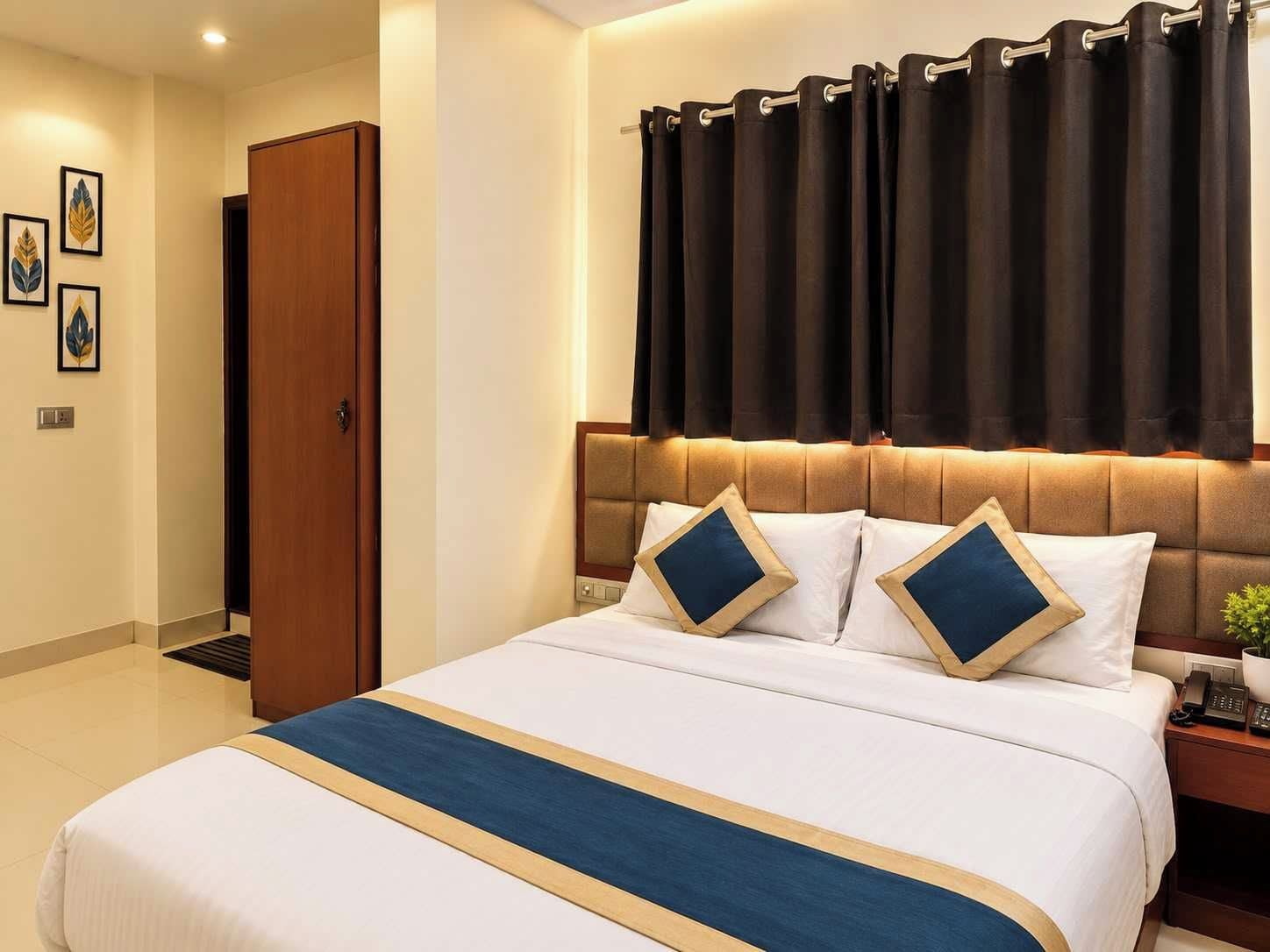 A hotel room with a large bed, a wooden door, and a curtain.