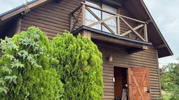 Une cabane en bois avec un balcon, une porte et une fenêtre.