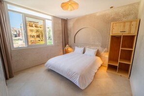 Un dormitorio con una cama, una ventana y un armario de madera.
