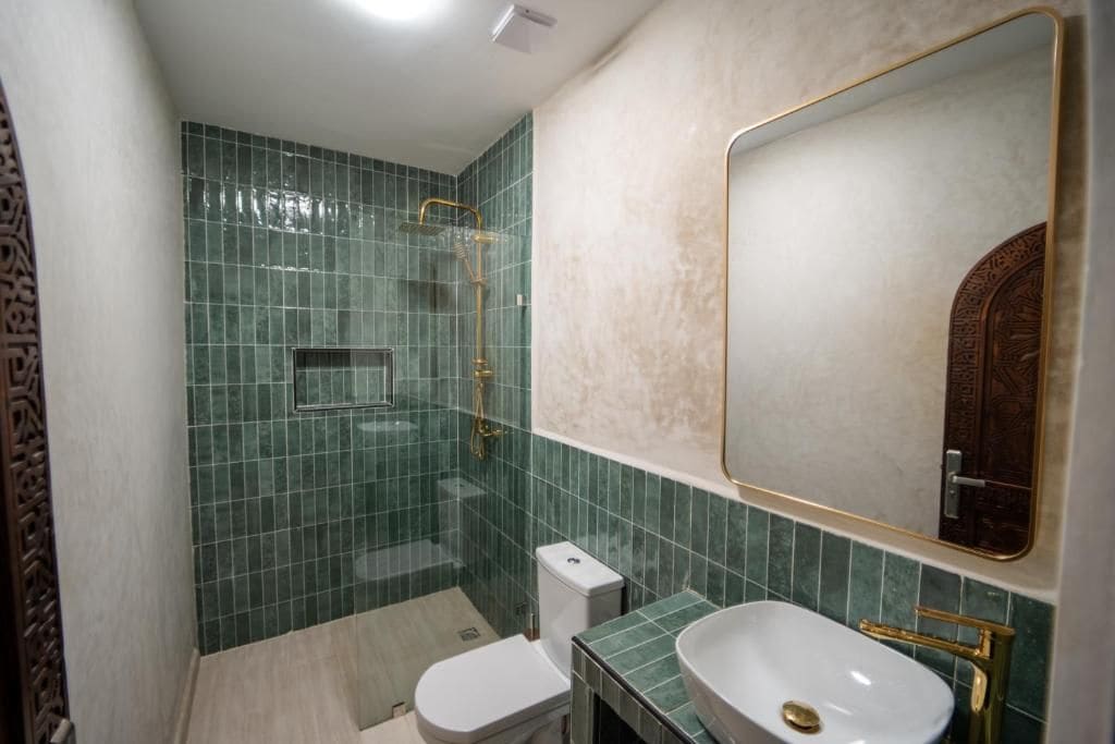 A bathroom with a toilet, sink, and shower.