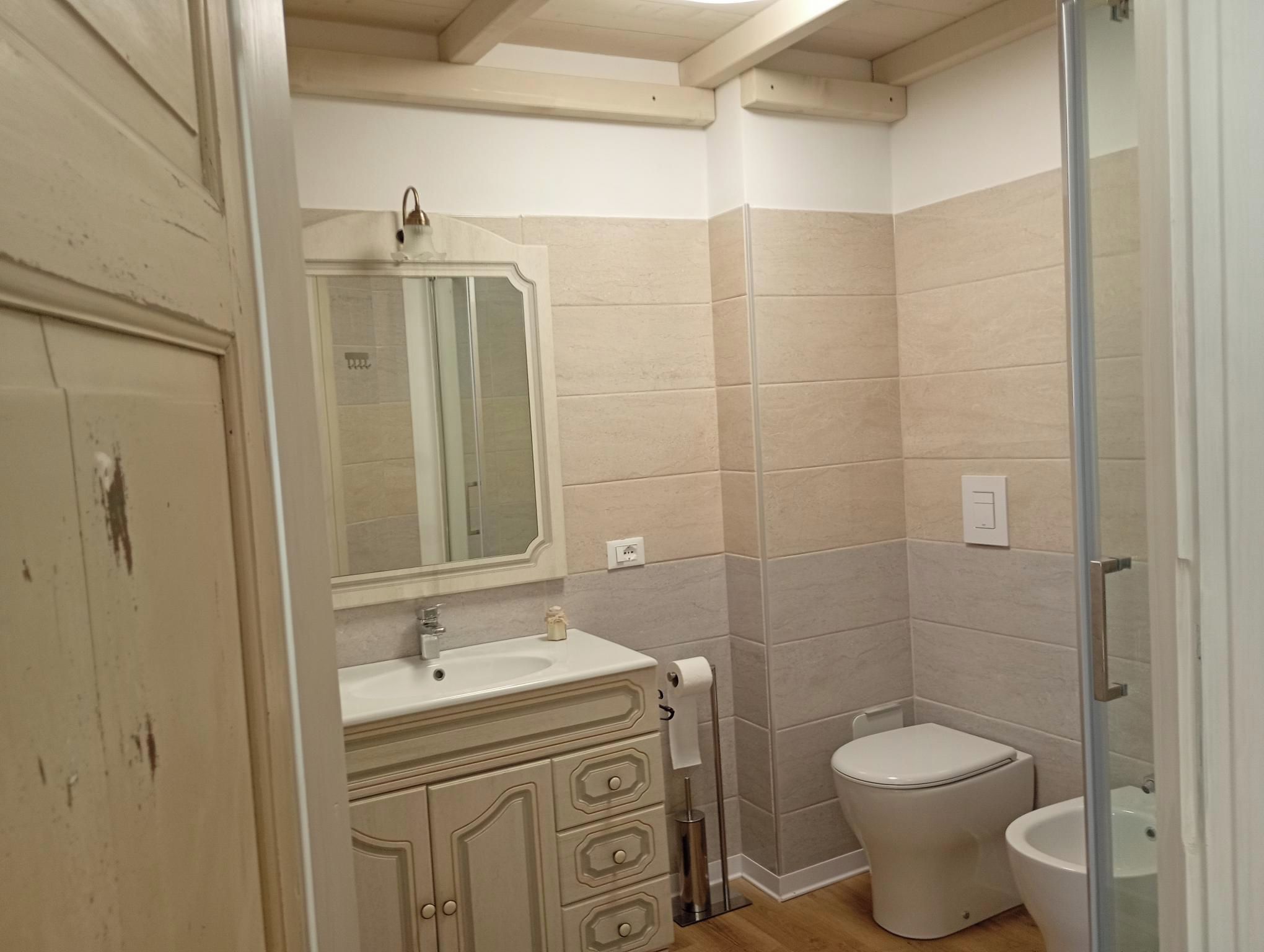 Ein Badezimmer mit Toilette, Waschbecken und Spiegel.