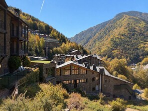 A mountain lodge with multiple buildings, including a main house with a sloped roof and a smaller structure with a flat roof. - Anyos Park Apartamentos (Anyos)