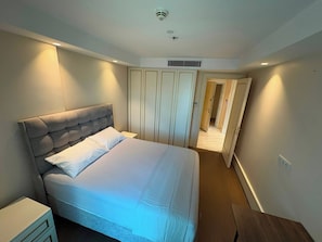 A bedroom with a bed, a wardrobe, and a door leading to another room. - Super Luxury Condo in Bomonti Elisiyum Art (Istanbul)