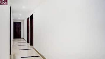 Un pasillo con un cartel que indica el primer piso, que conduce a una puerta al final.