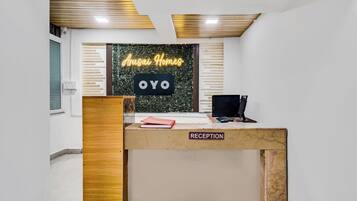 A reception desk with a sign reading 'Arusai Homes OYO' and a 'RECEPTION' label.