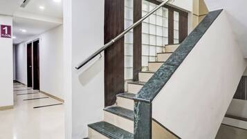 A modern staircase with a metal handrail, a wooden door, and a glass window.