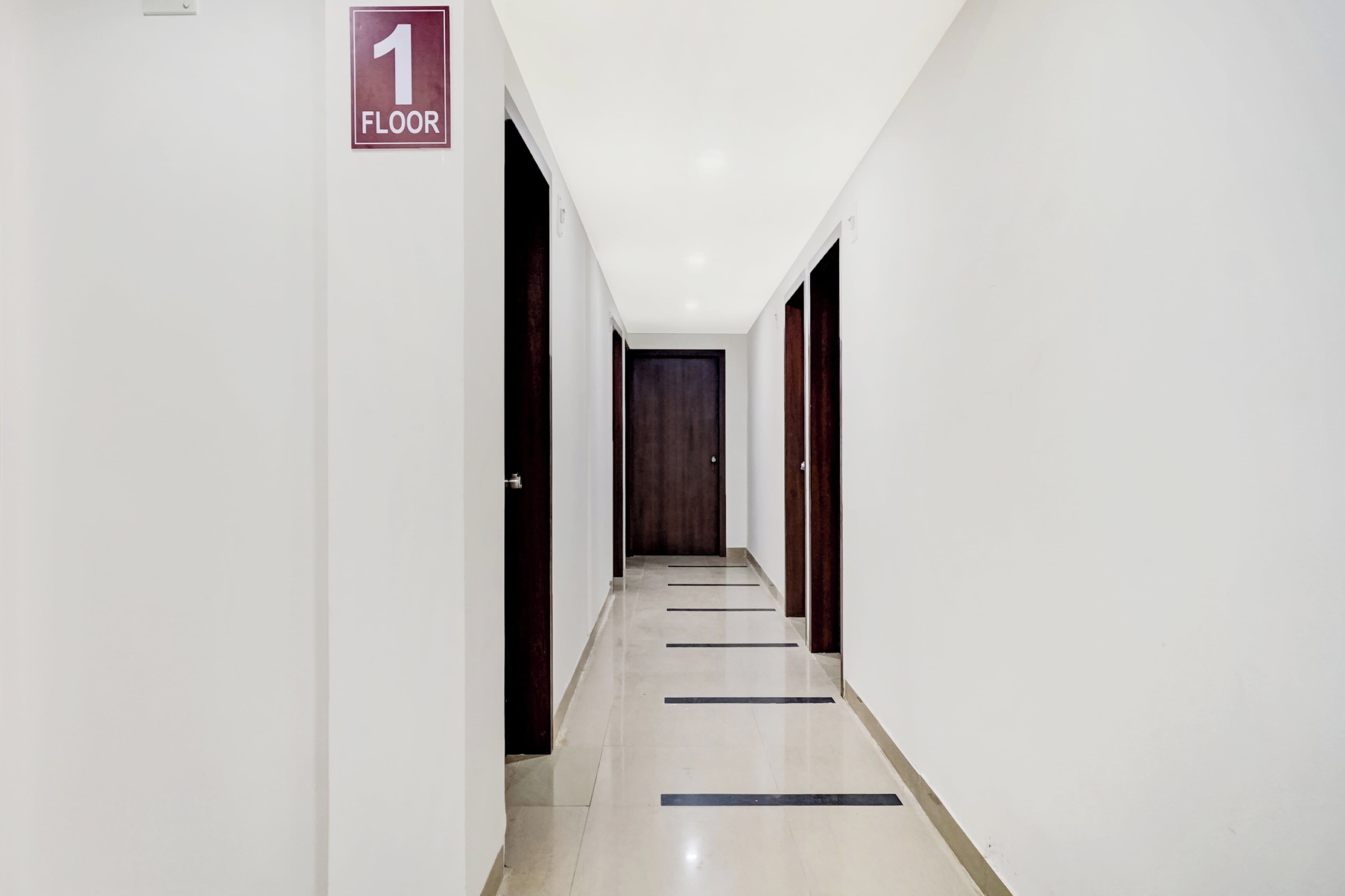 A corridor with a sign indicating the first floor, leading to a door at the end.