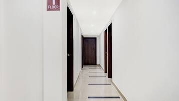 A corridor with a sign indicating the first floor, leading to a door at the end.