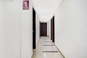 A corridor with a sign indicating the first floor, leading to a door at the end.