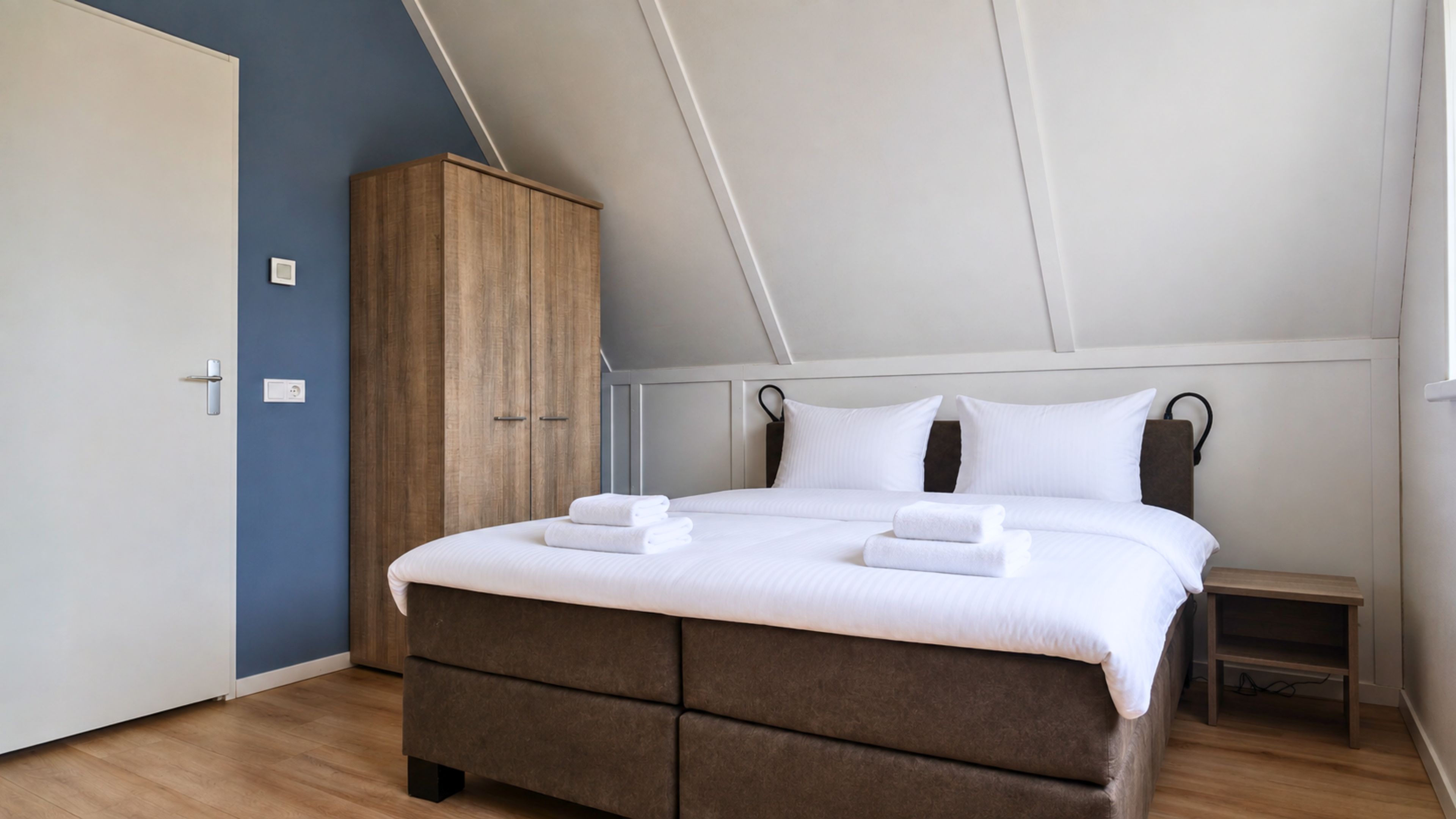 Ein Schlafzimmer mit einem Bett, einem Kleiderschrank und einem Nachttisch.
