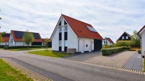 Eine Wohnstraße mit modernen Häusern, befestigten Straßen und gepflegten Rasenflächen.