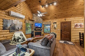 A log cabin interior with a fireplace, television, and cozy seating area. - The Honey Bear
Cabin #B
Lovely 2-bedroom cabin with AC in charming Cosby (Cosby)