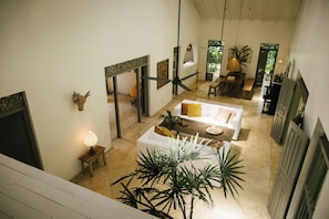 A spacious living area with a high ceiling, a dining table, and a sofa. - Oba Samaga by TONIK (Unawatuna)