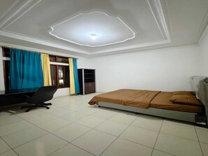 A bedroom with a bed, a desk, and a wardrobe. - Cozzy Villa Puri (BOGOR)
