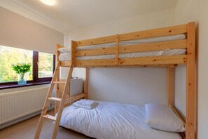 A bunk bed with a ladder, a window with a view of greenery, and a radiator. - Windmill Valley View (Nether Heage)