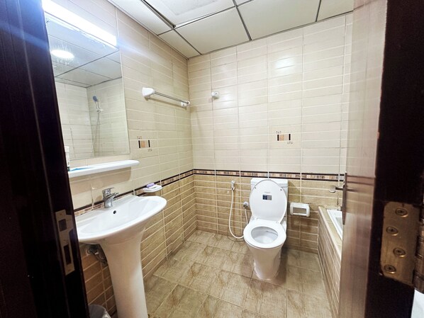 A small, tiled bathroom with a sink, toilet, and mirror. - Horizon View Partition Room in Tecom (Dubai)