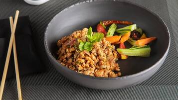 A bowl of food with chopsticks beside it.