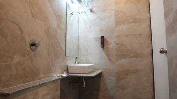 A bathroom with a toilet, sink, and shower.