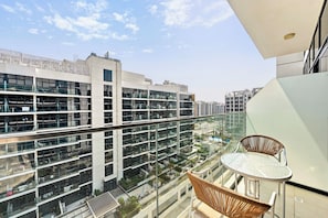 A high-rise building with multiple floors, large windows, and a view of a cityscape. - Bloomfields Studio in Azizi Riviera 43 (Dubai)