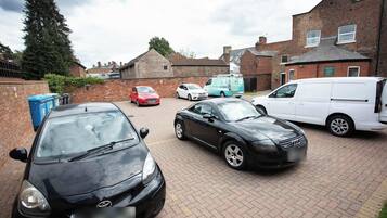 A residential street with parked cars and a white van.