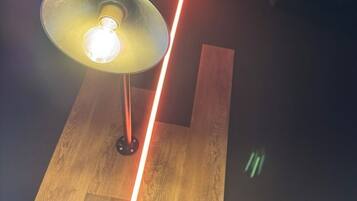 Een lamp met een zichtbare gloeilamp en een houten vloer.
