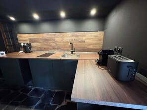 A modern kitchen with a wooden countertop, a sink, a coffee maker, and a toaster. - defaultName (Lacroix-Falgarde)