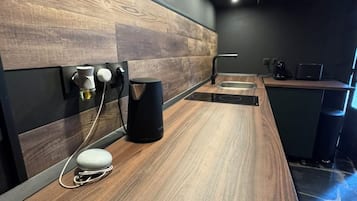A modern kitchen with a wooden countertop, a coffee machine, and a built-in oven.
