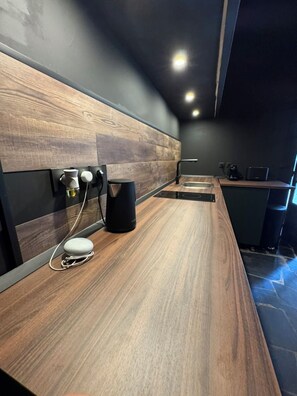 A modern kitchen with a wooden countertop, a coffee machine, and a built-in oven.