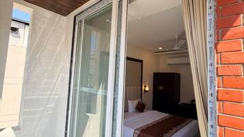 A room with a bed, a window, and a ceiling fan.