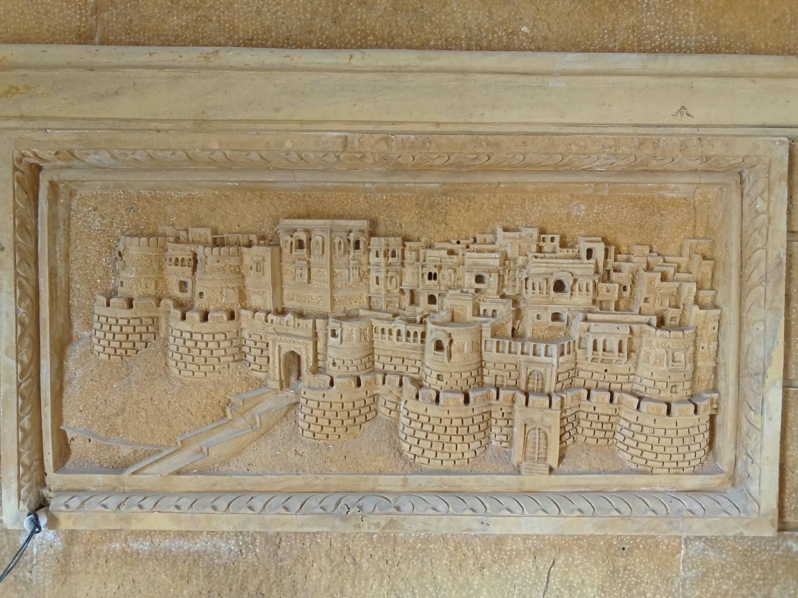 A detailed stone carving of a fortified city with multiple towers and walls.