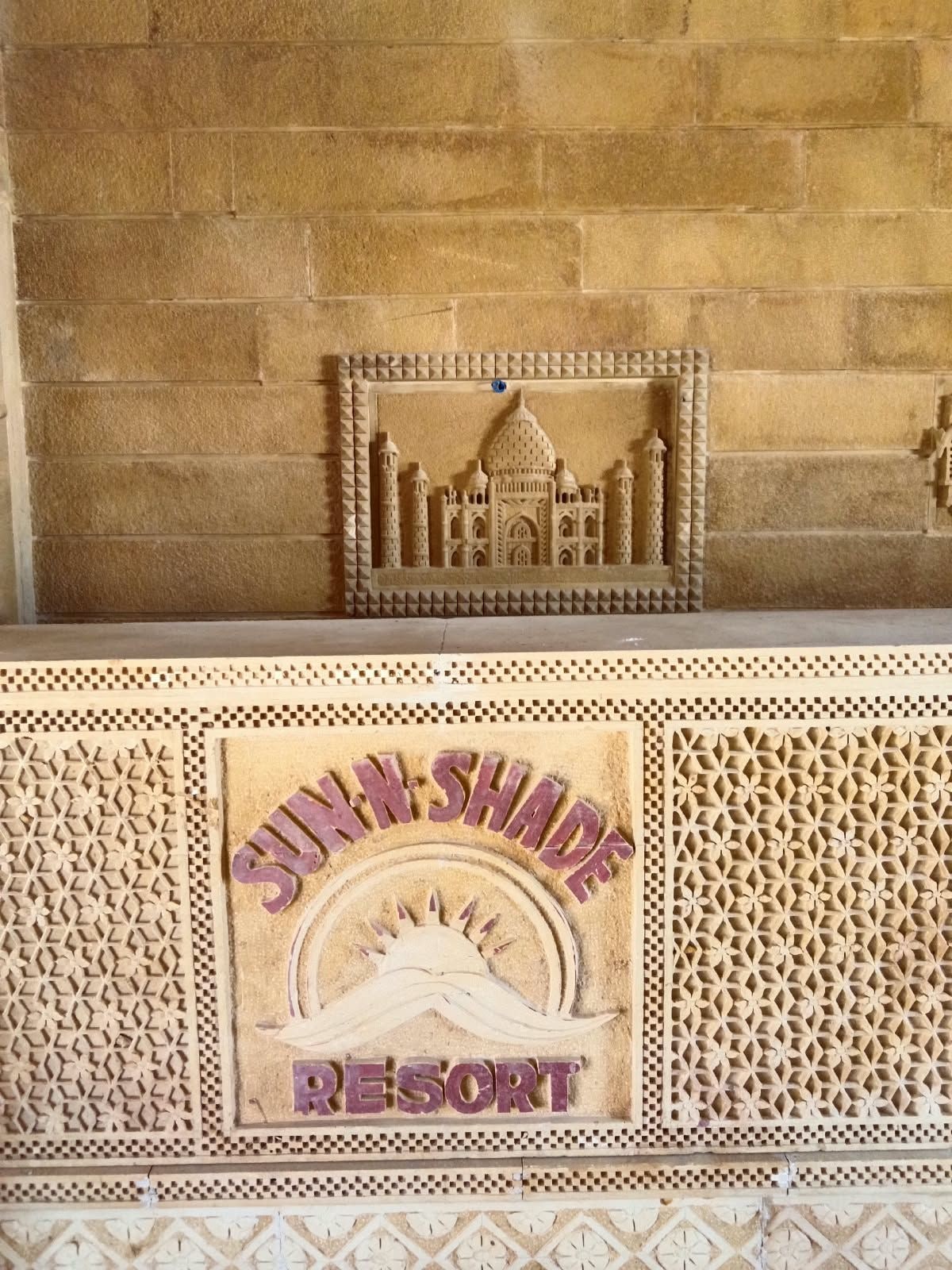 A carved architectural design with the text 'SUNSHAD RESORT' on a wall.