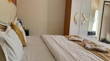 Una habitación de hotel con una cama, un armario y un espejo.