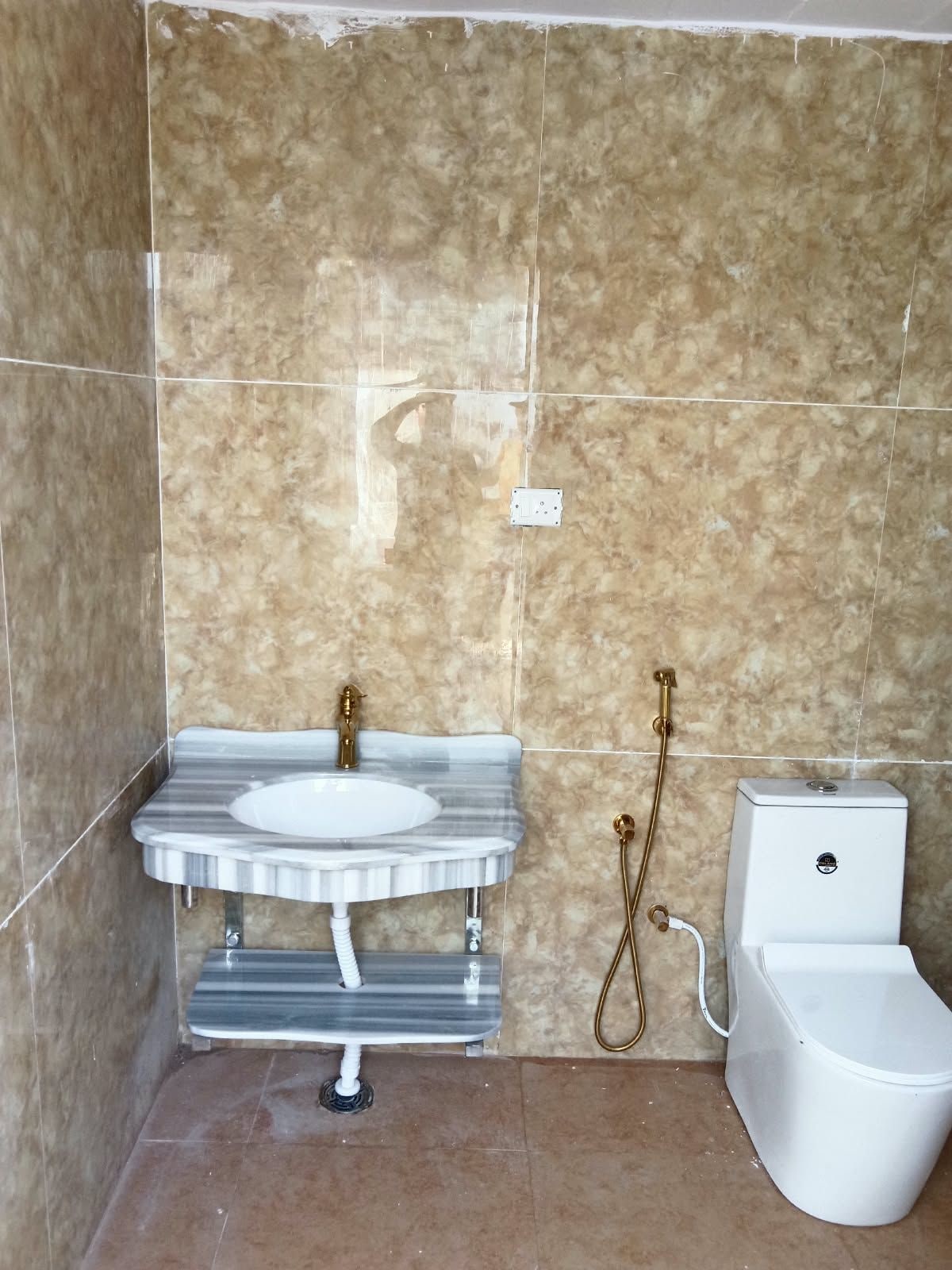 A bathroom with a marble sink, a toilet, and a shower.