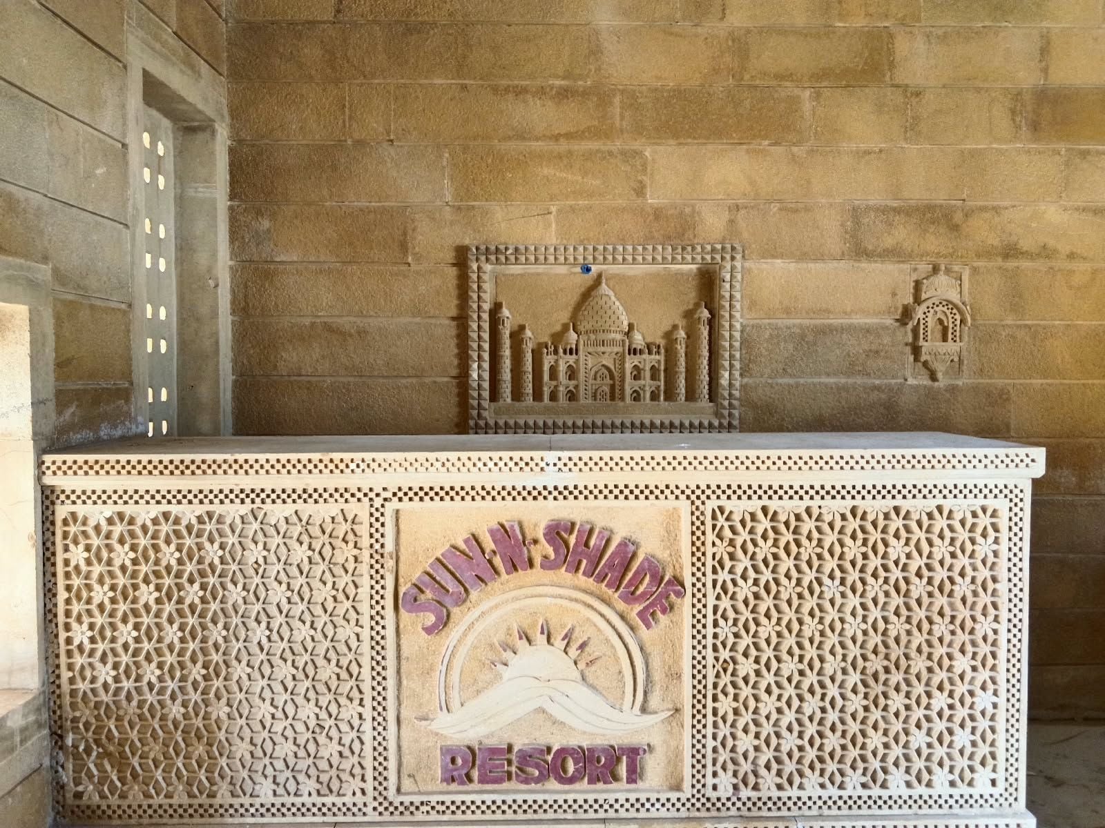 Una recepción con elaboradas tallas y un cartel que dice 'SUNSHADOW DESERT'.