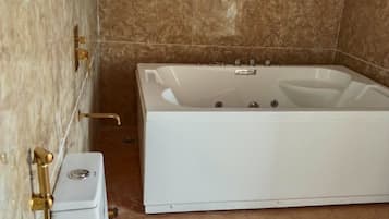 Un baño con bañera, inodoro y zona de ducha.