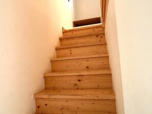 A wooden staircase with a handrail, leading to an upper floor. - Charming studio with a mezzanine and a courtyard with a lemon tree—a 5-minute walk to the old town (Faro)