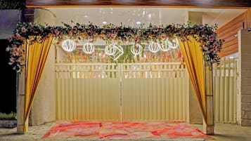 Une entrée fermée par un portail, agrémentée d’une arche ornée de fleurs et dotée d’un sol à motifs.