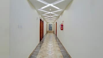 Un couloir doté d’un sol en marbre, de murs blancs et d’un plafond pourvu d’un éclairage encastré.