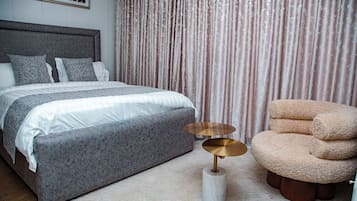 A bedroom with a bed, a round table, and a chair.