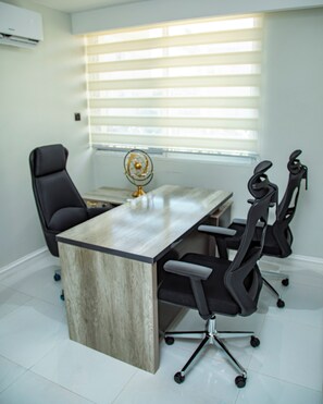 A modern office with a large table, black office chairs, and a globe decoration. - Villa De Fredwaa Unit 2 (Dar es Salaam)