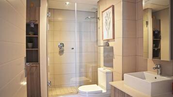 Ein modernes Badezimmer mit einer gläsernen Dusche, einer Toilette und einem Waschbecken.