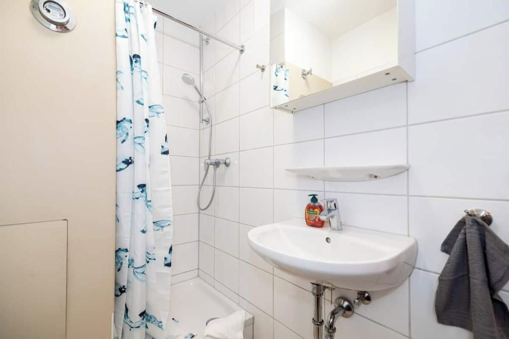 Ein Badezimmer mit Dusche, Waschbecken und Handtuchhalter.